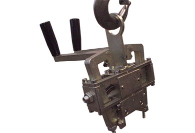 Custom steel lifting gripper hanging from a crane hook